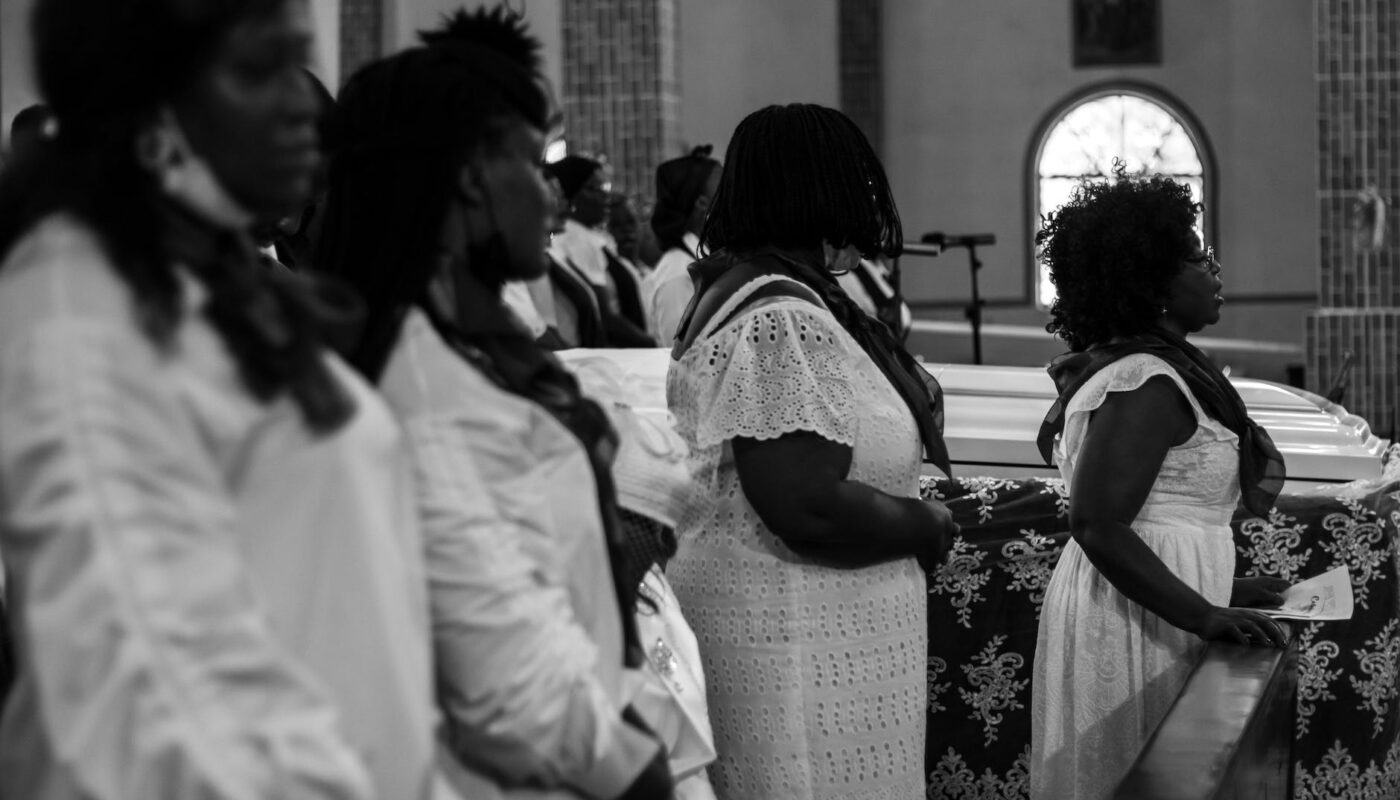 grayscale photo of women at a funeral