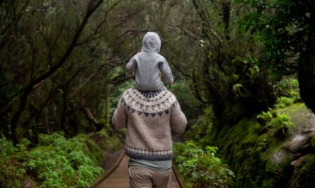 anonymous man with baby on shoulders walking away