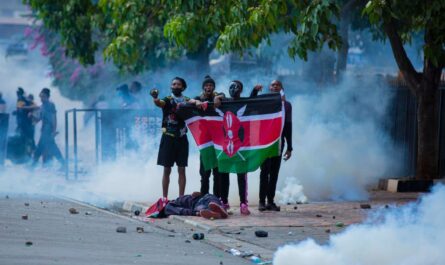 Protesters in Kenya hold up a flag next to a dead body, a victim of political demonstrations.