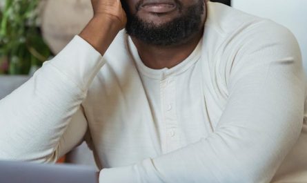 tired black man leaning on hand and looking away